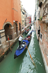 ourists floating in gondola in canal in Venice