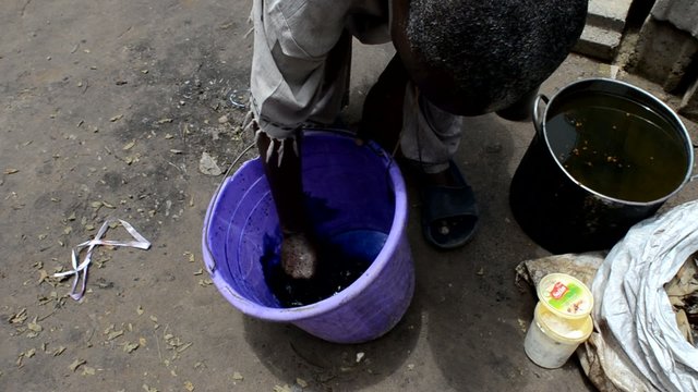African man prepares natural dye for fabrics 