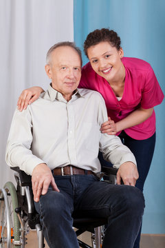 Nurse standing by the disabled in a wheelchair