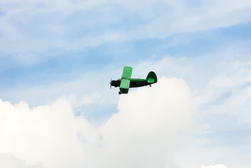 small green agriculturial aircrafte flying in sky