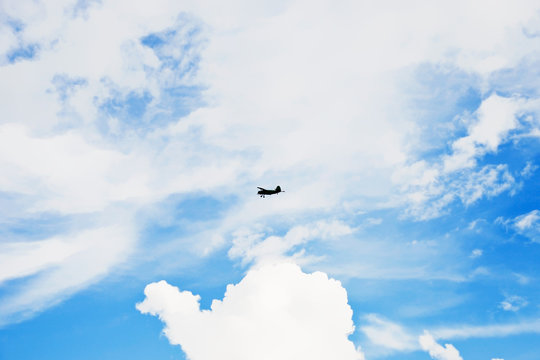 summer cloudscape with small green airplane