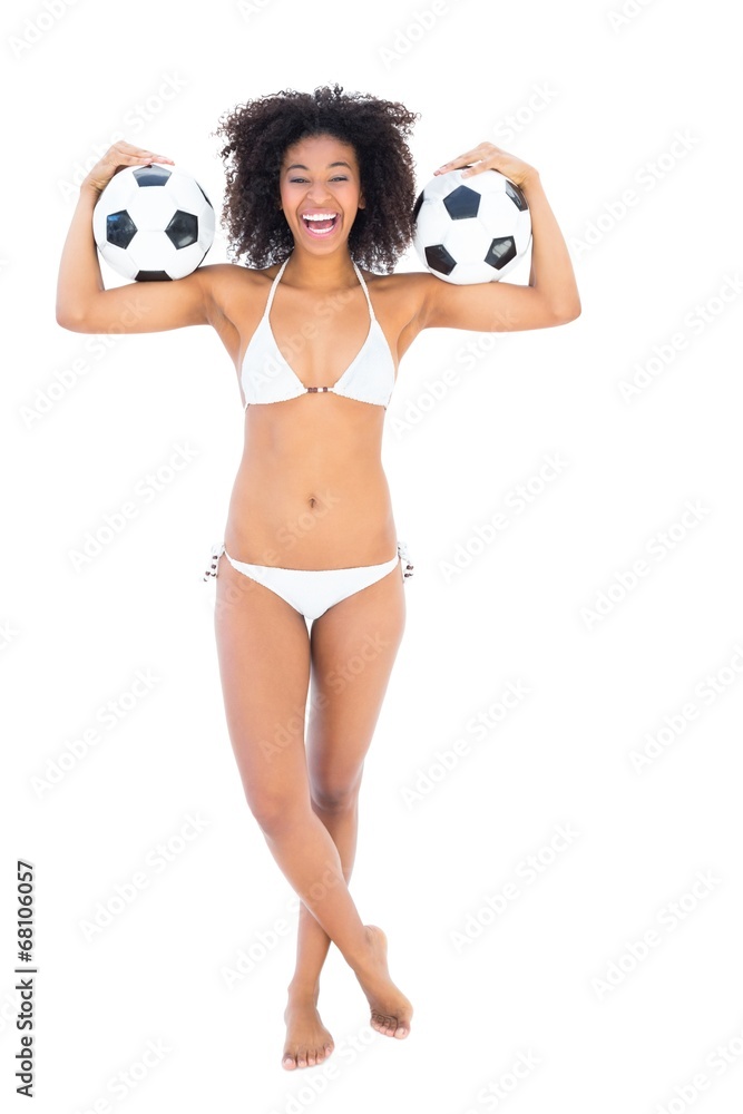 Wall mural excited fit girl in white bikini holding football