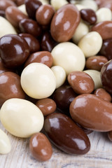 chocolate covered nuts and raisins on wooden surface