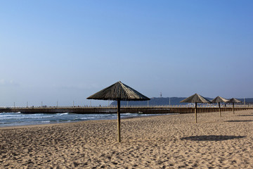 Row of Sun Shade Umbrellas on Empty Beach