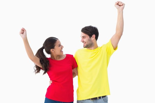 Excited couple cheering in red and yellow tshirts