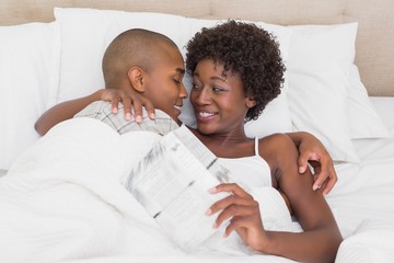 Happy couple lying in bed cuddling