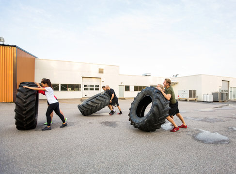 Athletes Doing Tire-Flip Exercise Outdoors