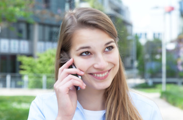 Attractive woman with blond hair laughing at phone