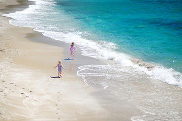 Two little sisters having fun on a beach