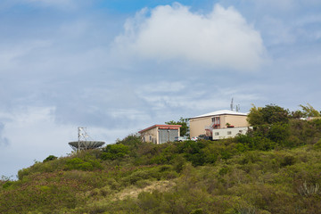 Fototapeta na wymiar Metal Buildings on Tropical Hill with Satellite Dish