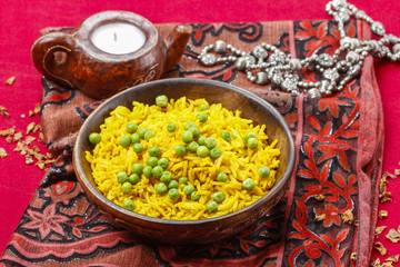 Indian cuisine: bowl of yellow rice with green peas