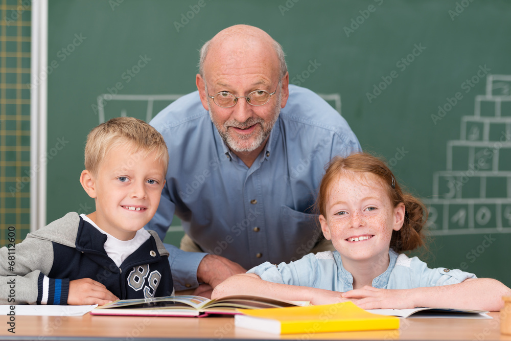 Poster lächelnder älterer lehrer mit zwei schülern im klassenzimmer