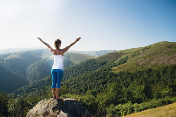 Young woman meditate on the top of mountain