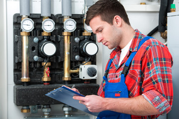 Technician servicing heating boiler