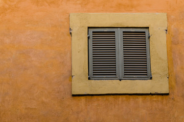 Fototapeta na wymiar old facade with closed window, Italy