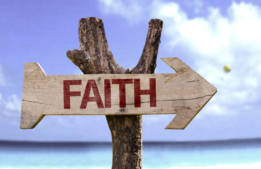 Faith wooden sign with a beach on background