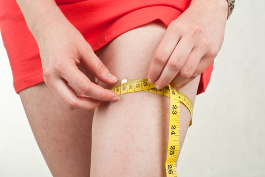 Photo of a woman's leg. She is measuring her thigh