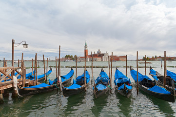 Moored gondolas in Venice at the pier . Italy.