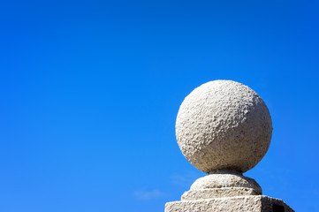 Fototapeta na wymiar stone ball against blue sky