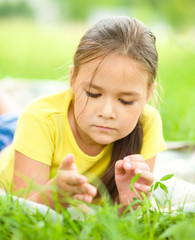 Portrait of a little girl laying on green grass