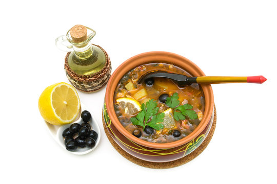 Thistle soup, olives, lemon and sunflower oil on a white backgro