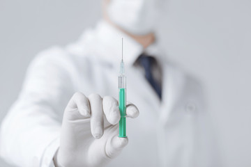 male doctor holding syringe with injection