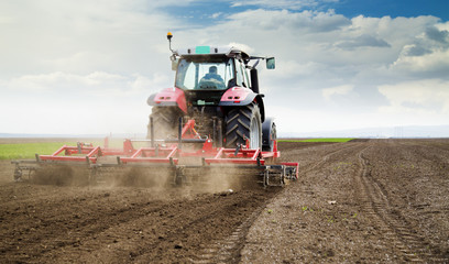 Obraz premium Farmer in tractor preparing land for sowing