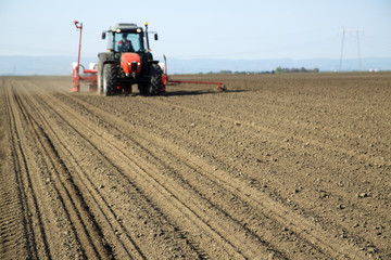 Obraz premium Farmer in tractor sowing crops at field