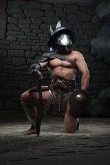 Fototapeta na wymiar Gladiator in helmet and armour holding sword