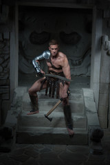 Gladiator in armour standing on steps of ancient temple with swo