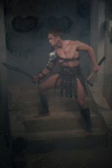 Fototapeta na wymiar Gladiator in armour standing on steps of ancient temple with swo