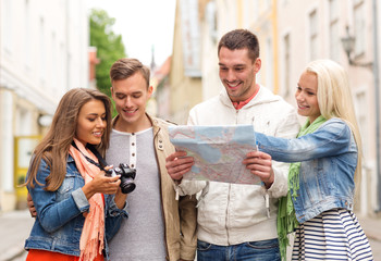 group of smiling friends with map and photocamera