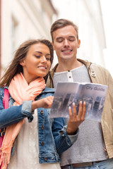 smiling couple with city guide exploring town