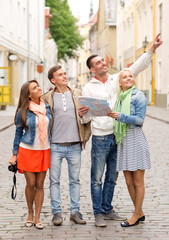 group of smiling friends with map and photocamera