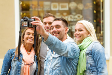 group of smiling friends making selfie outdoors