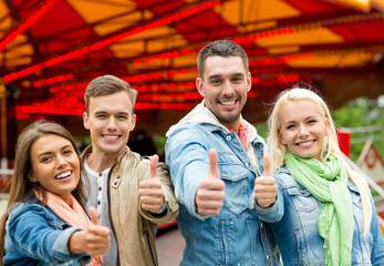 group of smiling friends showing thumbs up