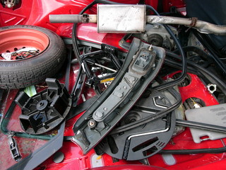 Ersatzteile und Reserverad im Kofferraum eines roten französischen Gebrauchtwagen der...