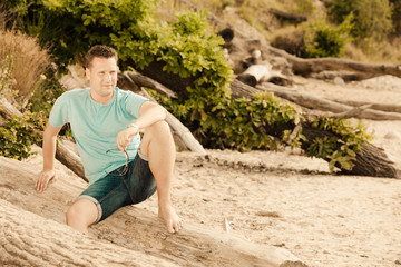 Fashion portrait handsome man sitting on tree