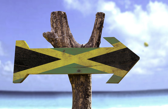 Jamaica wooden sign with a beach on background
