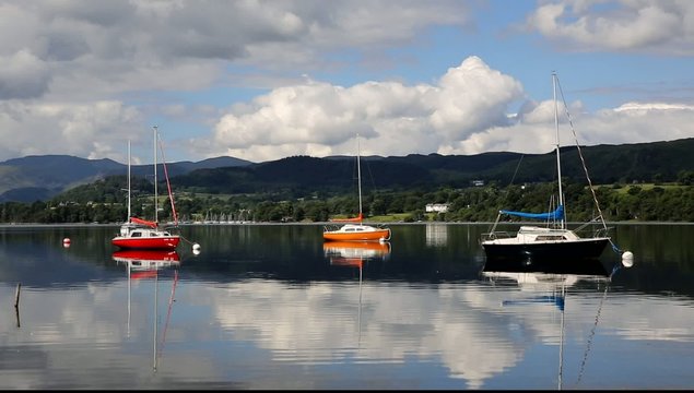 Colourful boats red orange and mountains Ullswater Lake District
