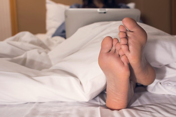 woman using laptop on the bed