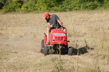 ouvrier sur une tondeuse auto portée