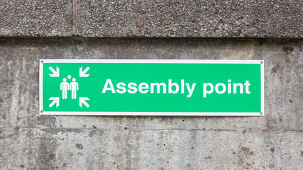 Green plastic 'assembly point' sign