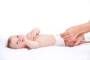 cute infant lying on white bed.