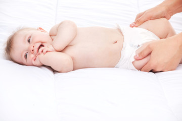 cute infant lying on white bed.