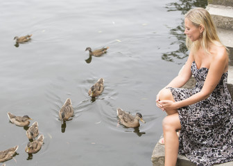 woman at a lake with ducks