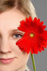 Portrait of a bright woman holding a red flower