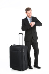 handsome guy standing with luggage in suit.