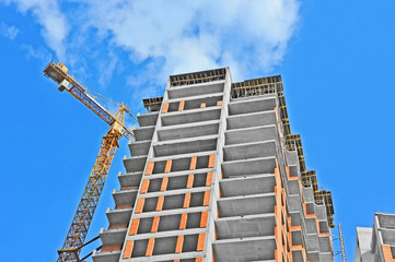 Crane and building construction site against blue sky