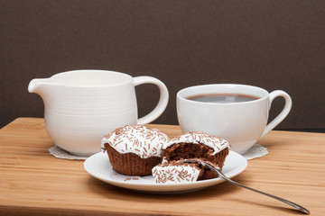 Fototapeta premium Cupcakes With Cocoa White Cream And Sprinkles. Coffee And Milk